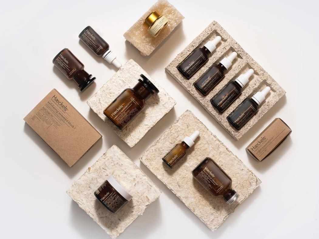 Compostable cosmetic packaging: amber serum and dropper bottles nested in moulded mycelium trays