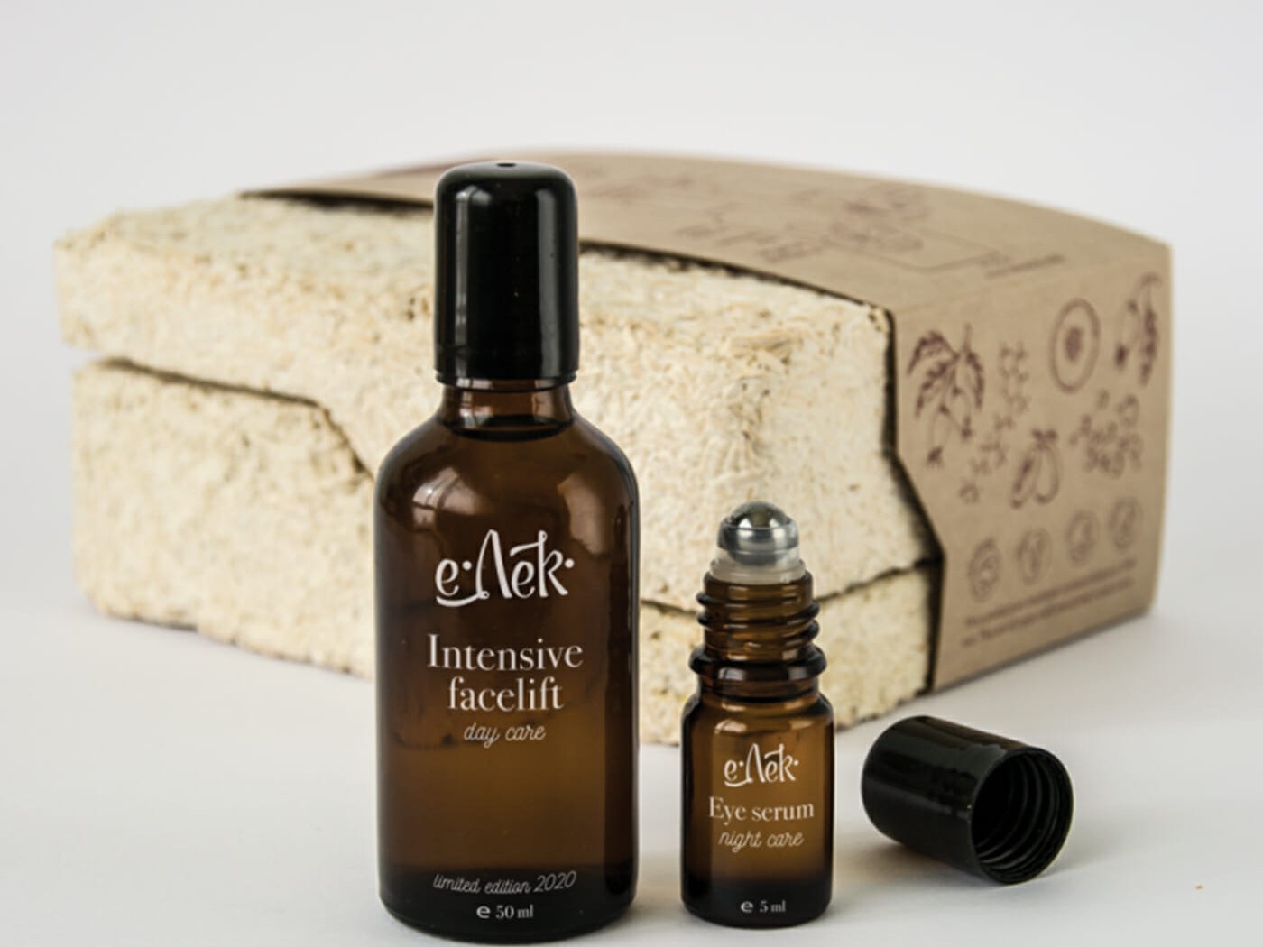 Biodegradable perfume packaging: amber perfume and roll-on bottles in front of a moulded mycelium box